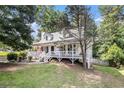 Charming two-story home with white siding, a lovely porch, and mature trees at 47 Glen Ridge Dr, Villa Rica, GA 30180