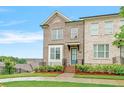 Charming brick townhouse with blue door, complemented by a well-manicured lawn and lush landscaping at 5217 Riden Ct # 263, Buford, GA 30518