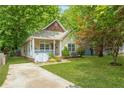 Inviting bungalow featuring a well-maintained lawn, driveway and mature shade trees at 747 Dill Sw Ave, Atlanta, GA 30310