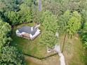Aerial view of the property showcasing the home, surrounding trees, and the fence lined yard at 128 Golden Hills Dr, Woodstock, GA 30189