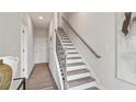 Entryway featuring wood and white stairs and runner, offering a clean, contemporary aesthetic with an abundance of natural light at 1305 Lakota Pl, Atlanta, GA 30315