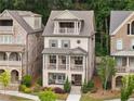 Three story brick home with double stacked covered porch on a manicured lawn at 2110 Timball Nw Rd, Atlanta, GA 30318