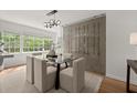 Elegant dining room with glass table, modern light fixture, and unique wine storage at 3915 Ivy Ne Rd, Atlanta, GA 30342