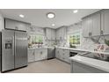 Modern kitchen with gray cabinets, stainless steel appliances, and marble backsplash at 3915 Ivy Ne Rd, Atlanta, GA 30342