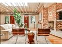 Spacious living room with exposed ceiling, hardwood floors, brick accent wall, and a cozy fireplace at 1933 Mclendon Ne Ave # A, Atlanta, GA 30307