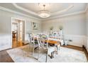 Bright dining room featuring hardwood floors, elegant wainscoting, a crystal chandelier, and ample natural light at 1975 River Forest Drive, Marietta, GA 30068