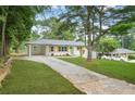 Quaint one-story home boasts a white exterior, lush green lawn, and a convenient covered carport at 4188 Fontana Ct, Tucker, GA 30084
