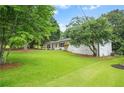 Spacious lawn surrounds a charming, one-story white home with a convenient carport in a peaceful setting at 4188 Fontana Ct, Tucker, GA 30084