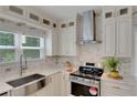 Gourmet kitchen featuring white cabinets, stainless appliances, marble countertops and backsplash, and natural light at 1095 Lyndhurst Way, Roswell, GA 30075
