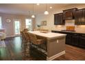 Open-concept kitchen with a large island, barstool seating, dark cabinets and modern appliances at 6298 Pierless Ave, Sugar Hill, GA 30518