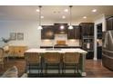Bright kitchen featuring an island with seating, sleek stainless steel appliances, and dark cabinetry at 6298 Pierless Ave, Sugar Hill, GA 30518