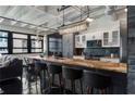 Open concept kitchen features a large island with seating, stainless steel appliances, and black painted flooring at 878 Peachtree St # 601, Atlanta, GA 30309