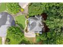 Aerial view of a gray roofed home surrounded by a lush green lawn, driveway and trees at 2015 Samuel Close Ct, Alpharetta, GA 30009