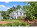 Charming two-story home with blue siding, manicured lawn, and mature trees at 1945 Barrett Dr, Cumming, GA 30040