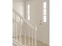 A bright, white paneled front door accented with decorative sidelights and staircase at 310 Wolf Downs Way, Atlanta, GA 30349