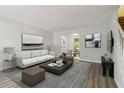 Inviting living room with modern decor, gray rug, and views into the dining area at 310 Wolf Downs Way, Atlanta, GA 30349