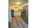 Modern kitchen featuring stainless steel appliances, white cabinets, and light wood floors at 3785 Somerset Sw Dr, Marietta, GA 30064