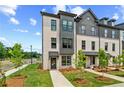Attractive townhome showcasing modern architecture, neat landscaping, and a welcoming entrance at 449 Breccia Run, Mcdonough, GA 30253