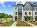 Stylish townhome exterior with white brick, black trim, and professionally landscaped front yard at 449 Breccia Run, Mcdonough, GA 30253