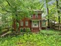 Charming two-story brick home with a covered front porch and partially overgrown landscaping at 1478 Oxford Ne Rd, Atlanta, GA 30307
