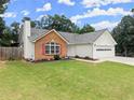 Charming single-story home featuring a brick facade, white siding, and a well-manicured lawn at 2605 Fort Apachee Trl, Dacula, GA 30019