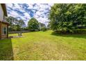 Expansive backyard featuring lush green grass and mature trees with a patio area, perfect for outdoor activities at 2870 Tattersall Ct, Cumming, GA 30041
