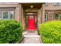 Inviting front entrance with a striking red door and stone accents framed by lush greenery at 2870 Tattersall Ct, Cumming, GA 30041