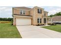 Side view of a two story brick home with a two car garage and a large driveway at 120 Aj Welch Jr Way, Mcdonough, GA 30252