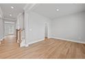Bright living room featuring hardwood floors, neutral paint, and a staircase to upper level at 120 Aj Welch Jr Way, Mcdonough, GA 30252