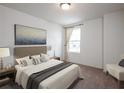 Bright bedroom features neutral decor, including a plush bed, side tables, and art at 1201 Fagiolo St, Mcdonough, GA 30253