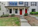 Exterior view of the townhouse with a red door, front porch and beautifully manicured front lawn at 3360 Pickens St, Duluth, GA 30096