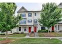 Charming townhome featuring a well-maintained lawn, brick facade, dark shutters and a red front door at 3360 Pickens St, Duluth, GA 30096