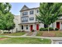 Charming townhome featuring a well-maintained lawn, brick facade, dark shutters and a red front door at 3360 Pickens St, Duluth, GA 30096