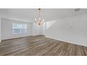 Bright living room featuring hardwood floors, a modern chandelier, and large windows for natural light at 7459 Old Chapel, South Fulton, GA 30349
