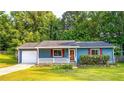 Charming single-story home with a well-manicured lawn, blue siding, and a cozy front porch at 1183 Iron Gate Blvd, Jonesboro, GA 30238