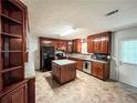 A traditional kitchen features wood cabinets, a tile backsplash, and an island for food preparation at 1183 Iron Gate Blvd, Jonesboro, GA 30238