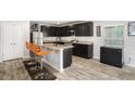 Modern kitchen with dark cabinetry, granite countertops, stainless steel appliances, and a breakfast bar at 12225 Anchor Way, Hampton, GA 30228