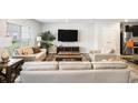 Bright living room featuring hardwood floors, large windows, and modern furnishings at 12225 Anchor Way, Hampton, GA 30228