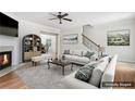 Bright living room featuring a fireplace, ceiling fan, and open access to other rooms, enhanced with staging at 626 Pecan Knoll Dr # 13, Marietta, GA 30008