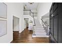 Grand foyer with high ceilings, wood floors, and staircase offers a welcoming entrance to the home at 9310 Chapelwood Dr, Johns Creek, GA 30022