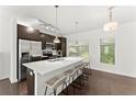 Well-lit kitchen with a central island, stainless steel refrigerator, and modern fixtures at 19 Moda Ln, Atlanta, GA 30316
