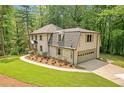 Home with a two-car garage, surrounded by a lush lawn and beautiful landscaping at 4800 Timberland Sw Dr, Mableton, GA 30126