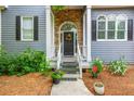 Inviting entrance with a stone archway, stylish door, and charming landscaping at 2045 Bethany Spring Trce, Cumming, GA 30041