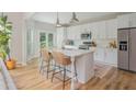 Modern kitchen featuring white cabinets, stainless steel appliances, a marble countertop island, and stylish seating at 2045 Bethany Spring Trce, Cumming, GA 30041