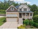 Charming two-story home featuring a stone facade, covered porch, and an attached two-car garage at 402 Homestead Dr, Dallas, GA 30157