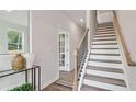 Stylish staircase featuring a decorative banister, carpeted steps, and access to the upper level at 1303 Lakota Pl # 20, Atlanta, GA 30315