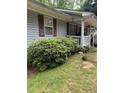 Charming home featuring light gray siding, red shutters, a covered front porch, and well-maintained landscaping at 6305 Eidson Dr, Cumming, GA 30041