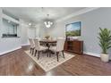 Elegant dining room with decorative light fixture and hardwood floors next to an open kitchen at 3334 Peachtree Ne Rd # 614, Atlanta, GA 30326