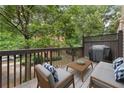 Cozy outdoor wooden deck with seating area, grill, and string lights at 5147 Manerdale Se Dr # 5, Vinings, GA 30339