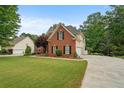 Beautiful brick home featuring manicured landscaping, large green lawn and long driveway at 1012 Chestnut Creek Dr, Villa Rica, GA 30180